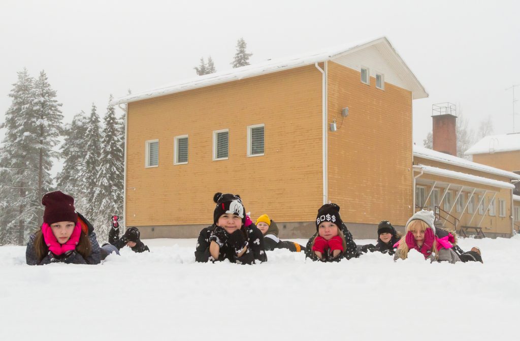 School pupils lay on snowy schoolyard of Noukavaara