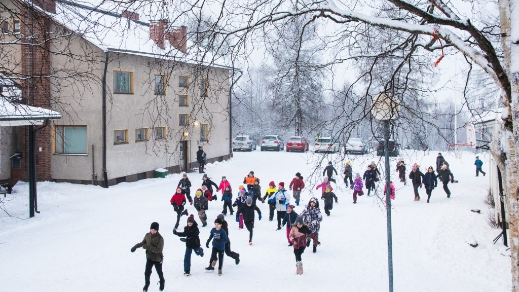 Mäkelän koululaiset kirmaavat lumisella koulupihalla.