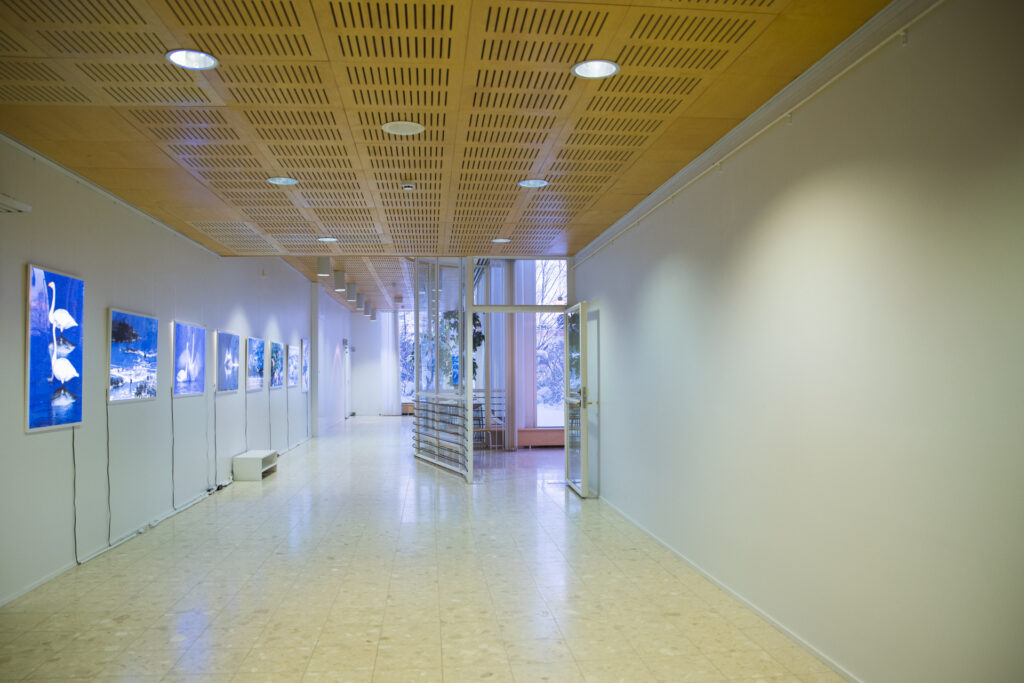 Kuvassa avautuu näkymä Kuusamotalon alalämpiön käytävälle, jonka seiniä voi käyttää näyttelytilana.