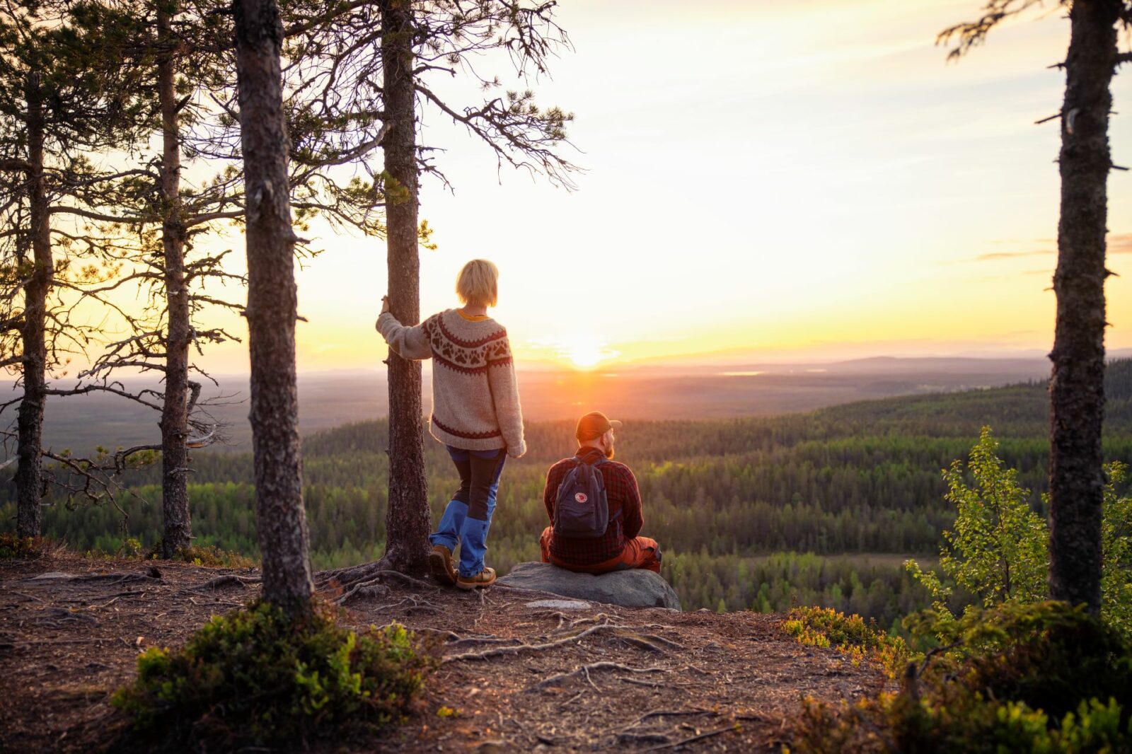 Retkeilijät katsovat maisemaa vaaran laella